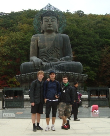 Student posing in front of Buddha statue