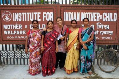 Women standing in front of IIMC sign