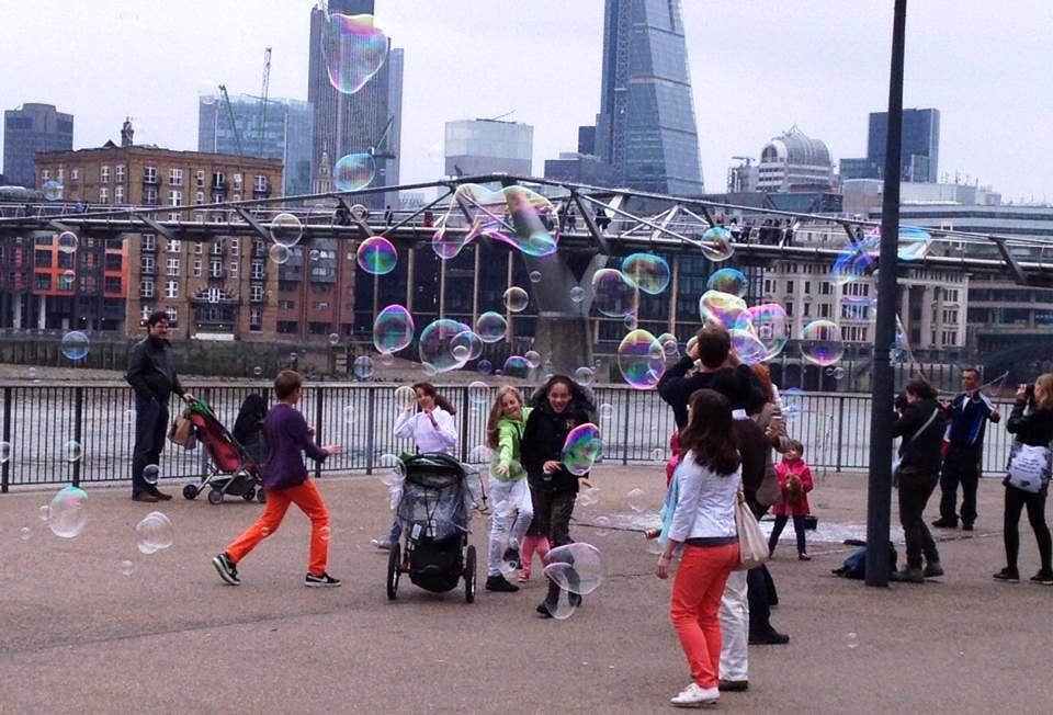Children playing with bubbles in the city