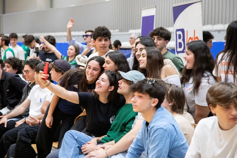 Students taking a group selfie during a match in the Bocconi Sport Center.
