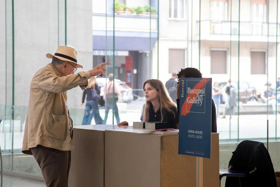 Young staff members giving directions to a visitor for the Bocconi Art Gallery.