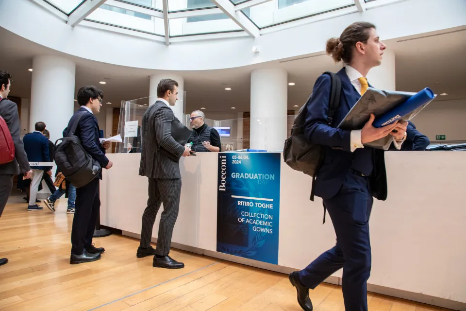 Studenti in fila per ritirare le toghe per la cerimonia di laurea.