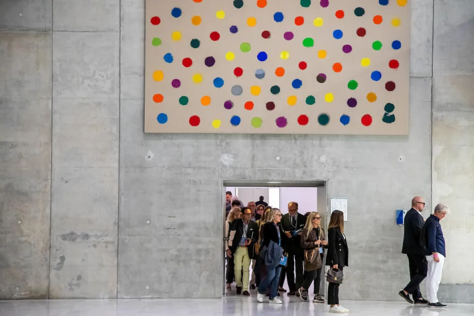 Bocconi Art Gallery visitors walking under a colorful artwork authored by Zeniuk.