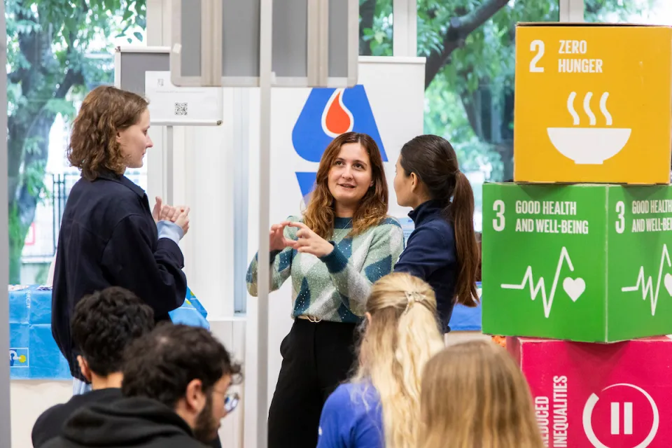 An AVIS volunteer chats with some students in the Campus Life halls. 