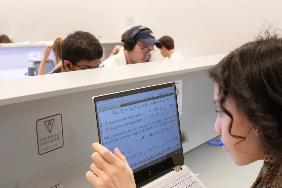 A student with a visual impairment studying at a computer in the Library.
