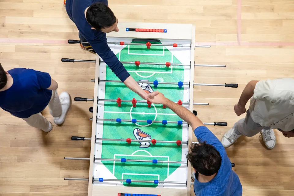Students shaking hands after a table football match, Castiglioni Residence.