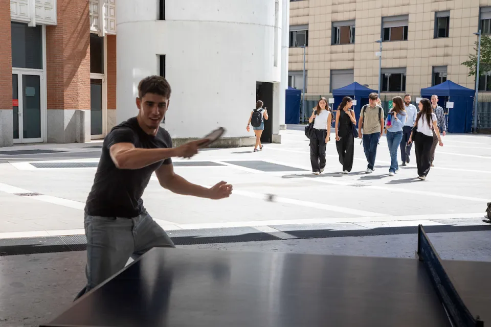 Uno studente gioca a ping pong in una pausa di lezione.