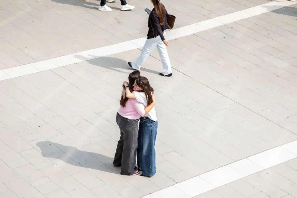 Due studentesse si abbracciano negli spazi di Campus Life.