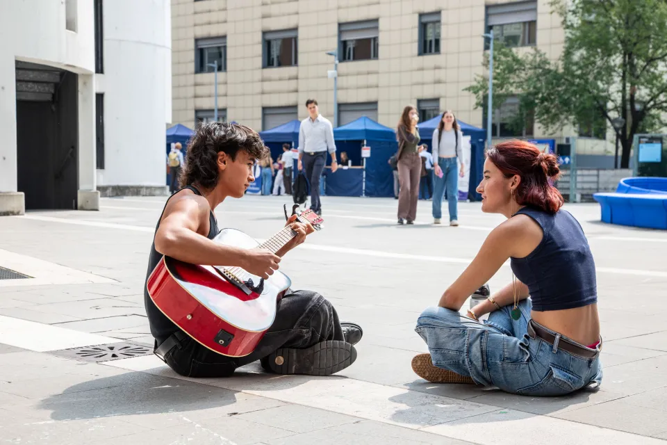 A student playing guitar during a break on Campus.