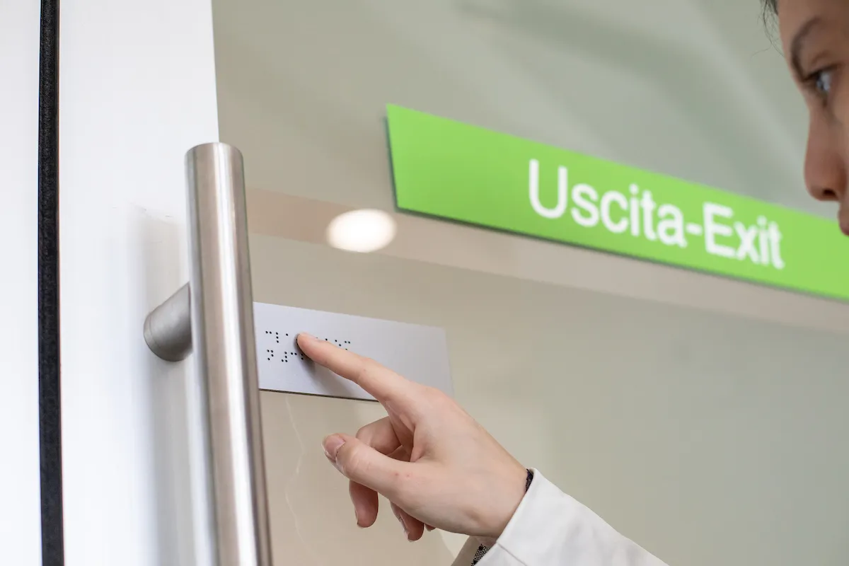 Student reading braille sign